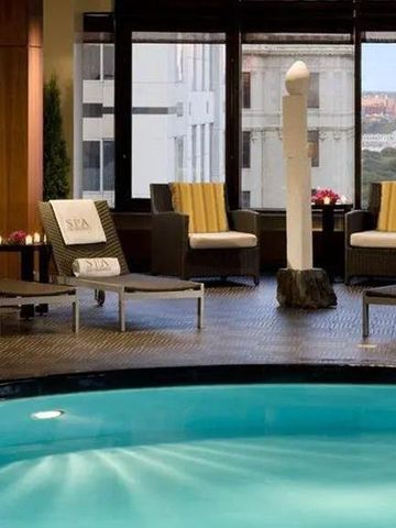 Luxuriöser Innenpoolbereich mit Liegen und Stadtblick durch Fenster