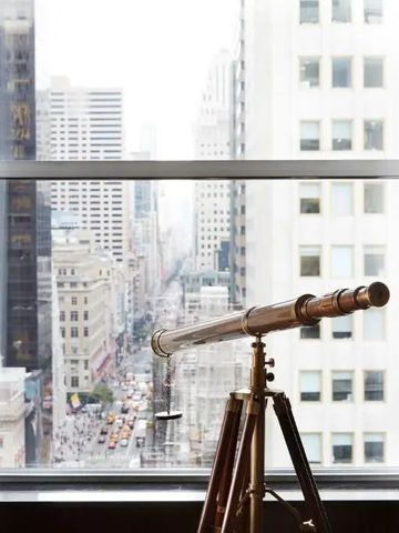 Teleskop am Fenster mit Blick auf New Yorker Stadtlandschaft