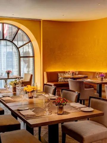 Eleganter Essbereich mit gelben Wänden und großen Fenstern