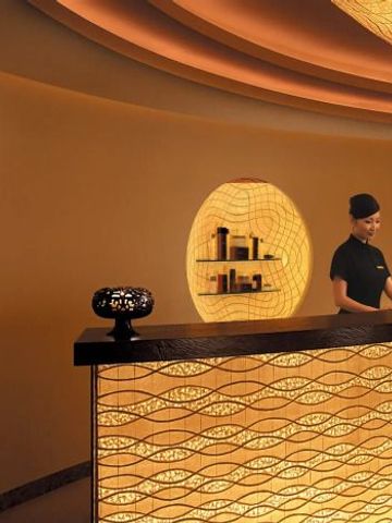 Elegante Rezeption im Spa-Bereich des The Peninsula Tokyo mit sanfter Beleuchtung.