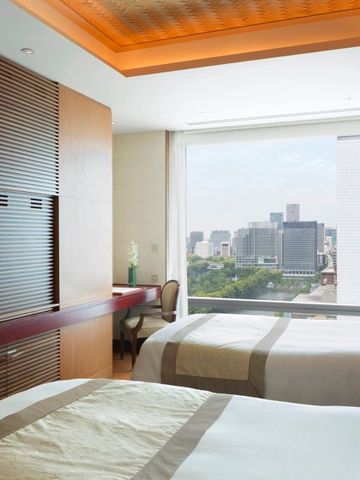 Zweibettzimmer mit großem Fenster und Stadtblick im The Peninsula Tokyo.