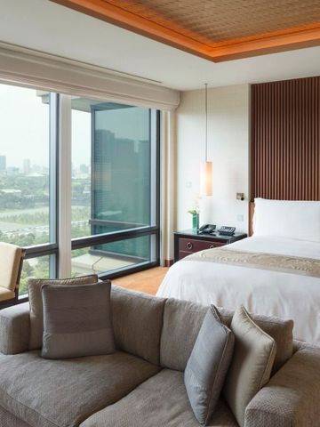 Luxuriöses Schlafzimmer mit Panoramafenster und stilvollem Design im The Peninsula Tokyo.