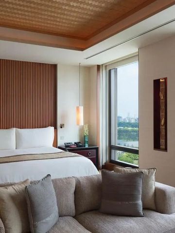 Hotelzimmer mit gemütlicher Sitzecke und Blick auf grüne Landschaft