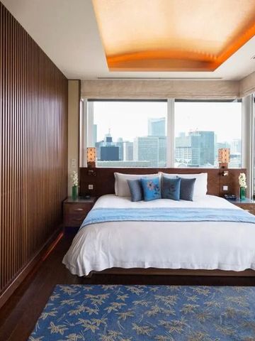 Hotelzimmer mit elegantem Dekor und breiten Fenstern mit Stadtansicht