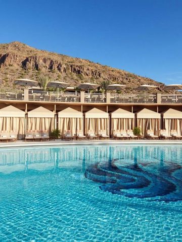 Poolbereich mit privaten Cabanas und Bergen im Hintergrund