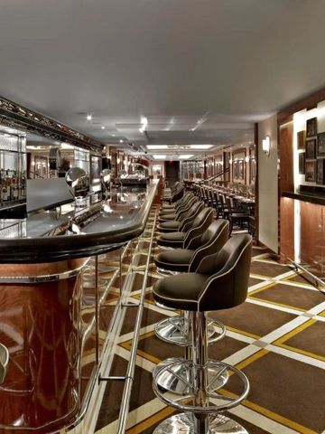 Luxuriöse Bar mit ledernen Hockern und moderner Ausstattung