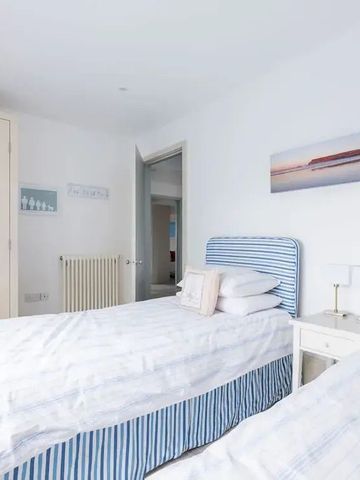 Lichtdurchflutetes Schlafzimmer mit zwei Einzelbetten und maritimer Dekoration.