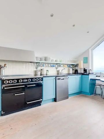 Moderne Küche mit blauen Schränken und großen Fenstern