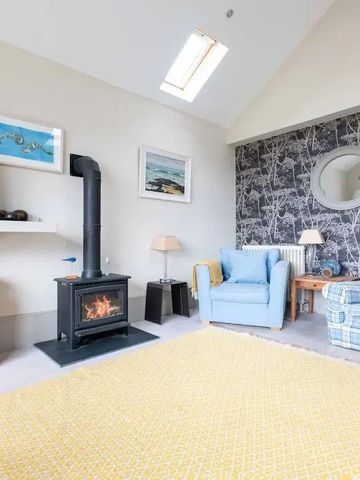 Wohnbereich mit Kamin, gelbem Teppich und blumiger Tapete