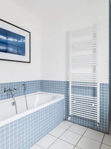 Modernes Badezimmer mit blauen Fliesen und Badewanne