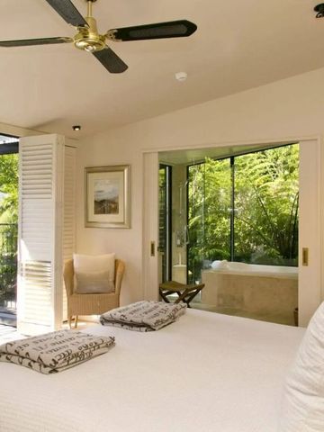 Helles Schlafzimmer mit Blick auf grüne Natur durch große Fenster