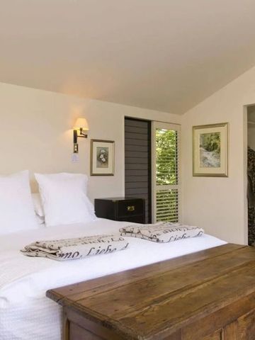 Elegantes Schlafzimmer in einer Villa mit Holztisch und gemütlichen weißen Kissen.