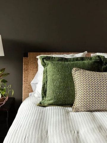 Elegantes Hotelzimmer mit grünen Kissen und modernem Nachttisch.