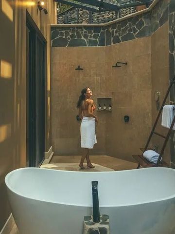 Elegantes Badezimmer mit freistehender Wanne und Steindetails.