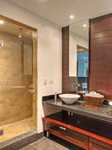 Modernes Badezimmer im Hotel mit eleganten Waschbecken und gläserner Dusche.