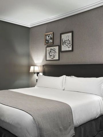 Modernes Hotelzimmer mit großem Doppelbett und stilvollen Akzenten.