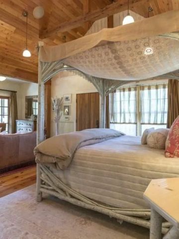 Luxuriöses Schlafzimmer mit Himmelbett in warmer Holzausstattung