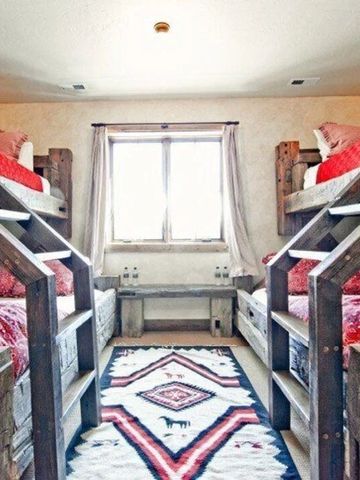 Zimmer mit mehreren Etagenbetten und rustikaler Einrichtung
