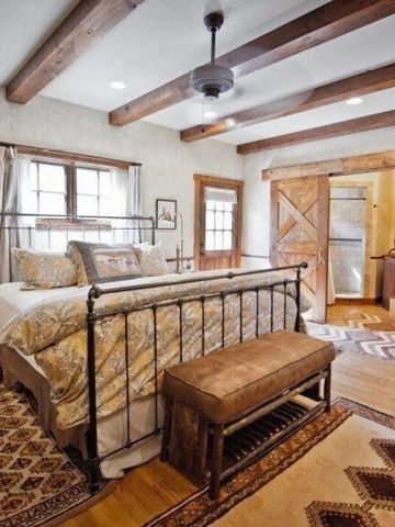 Rustikales Schlafzimmer mit Holzbalken und gemütlichem Bett