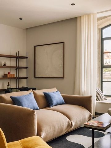 Gemütliche Lounge im Hotel mit Sofa und großem Fenster