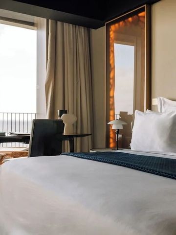 Hotelzimmer mit großem Bett und Balkon mit Blick auf das Meer