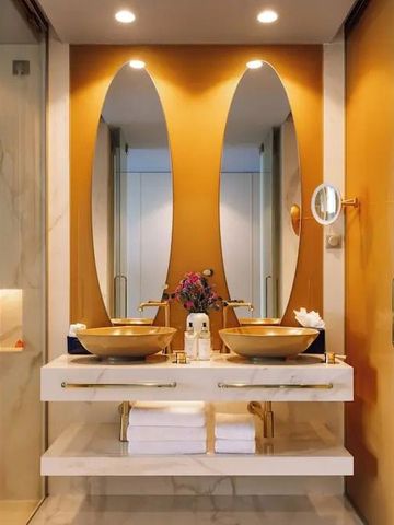 Modernes Badezimmer mit luxuriösem Doppelwaschbecken und goldenen Akzenten.