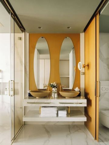 Luxuriöses Badezimmer mit Doppelwaschbecken und goldenen Akzenten