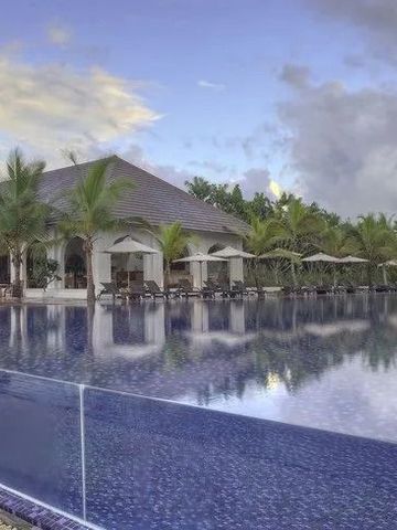 Großer Außenpool vor einem eleganten Gebäude mit Palmen