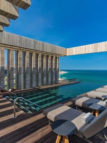 Infinity Pool auf einer Terrasse mit Blick auf das Meer und elegantem Sonnendeck.