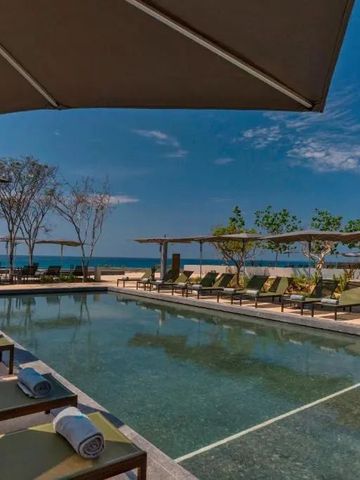 Pool mit Meerblick und luxuriösen Sonnenliegen unter Sonnenschirmen.