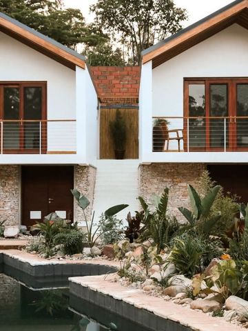 Zwei Villen mit Holzfassade und üppigem Garten am Pool