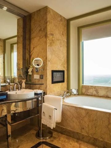 Luxuriöses Badezimmer mit Marmor und Badewanne mit Ausblick