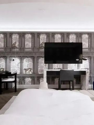 Luxuriöses Zimmer mit kunstvoller Wandtapete und großem Fernseher