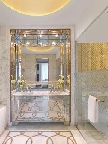 Badezimmer mit marmorner Ausstattung und elegantem Spiegel