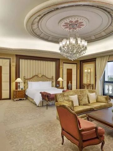 Prächtiges Schlafzimmer mit Kronleuchter und eleganter Möblierung, großem Fenster.