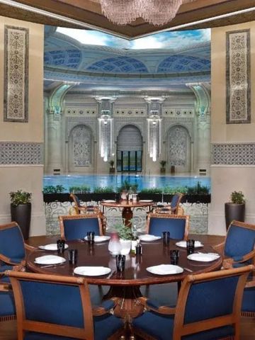 Hochklassiges Restaurant mit aufwändigen Verzierungen und gedeckten Tischen.