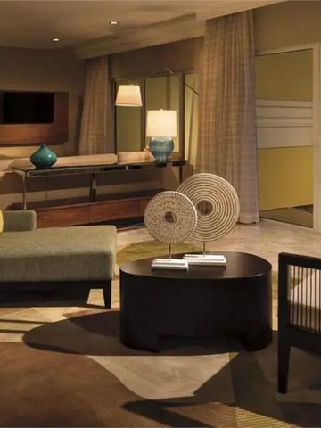 Elegantes Wohnzimmer einer Hotelsuite mit moderner Einrichtung und sanfter Beleuchtung.