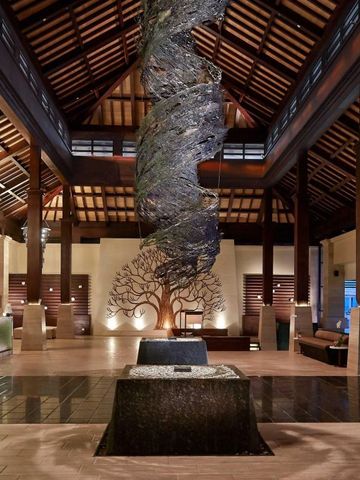 Beeindruckende Hotellobby mit kunstvoller Deckengestaltung und Skulptur.