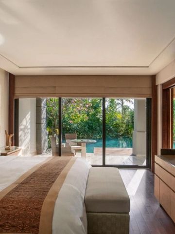 Helles Schlafzimmer mit Blick auf die Terrasse und den Pool.