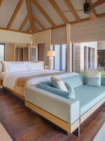 Geräumige Villa mit Holzbalken, großem Bett und Sofa im Resort-Stil