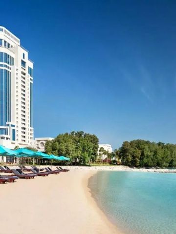 Privatstrand mit Sonnenliegen und türkisfarbenem Wasser beim The Ritz-Carlton Doha