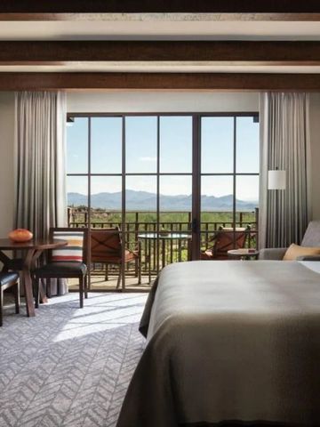 Elegantes Gästezimmer mit Balkonblick auf die Berge, stilvolles Interieur.