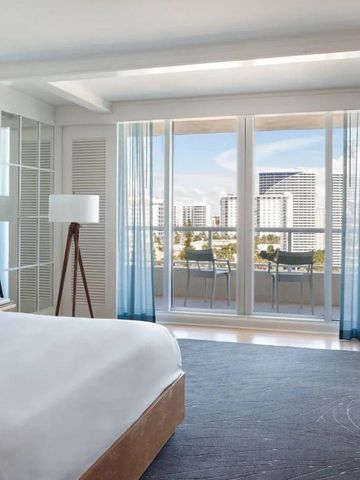 Geräumiges Schlafzimmer mit großem Fenster und Aussicht auf die Stadt