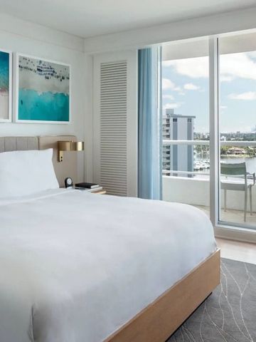 Gemütliches Schlafzimmer mit großem Fenster und Blick auf Wasserwege