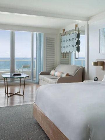 Helles Hotelzimmer mit großem Bett und Blick auf den Ozean