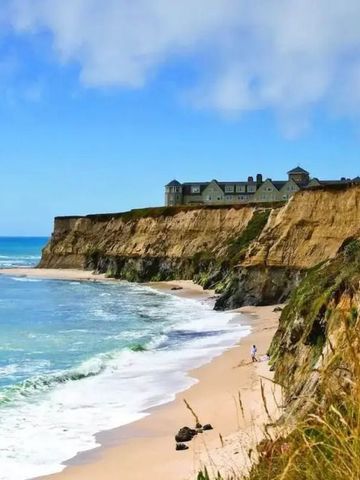 Klippenlandschaft mit Meerblick und Hotelanlage im Hintergrund