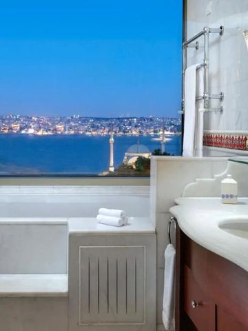 Luxuriöses Badezimmer mit Blick auf das beleuchtete Istanbul bei Nacht.