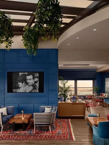 Elegante Lounge mit blauen Akzenten und Pflanzen hängend von der Decke