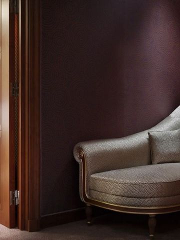 Luxuriöse Chaiselongue in einem Raum mit Holztür