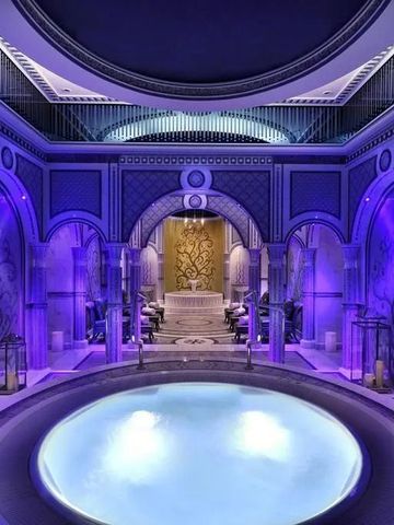 Luxuriöser Spa-Bereich mit beleuchtetem Pool und kunstvollen Wandverzierungen